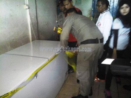 Petugas sedang memasang segel di salah satu freezer di gudang ayam impor melik Beyam.