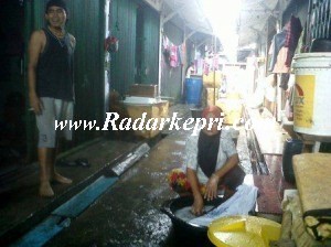 Seorang ibu rumah tangga sedang mencuci ketika Bupati Tanjungbalai Karimun berkunjung.