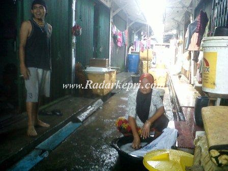Seorang ibu rumah tangga sedang mencuci ketika Bupati Tanjungbalai Karimun berkunjung.