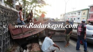 Truk pengangkut pasir yang terperosok kedalam parit karena di salip motor.