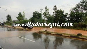 Jl di kilometer 13 arah Tanjung Uban yang tergenang air karena tidak adanya saluran pembuangan air (drainase).