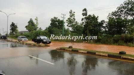 Jl di kilometer 13 arah Tanjung Uban yang tergenang air karena tidak adanya saluran pembuangan air (drainase).