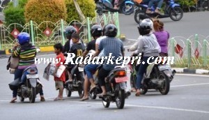 Asmahul menawarkan koran ke pengedara motor.