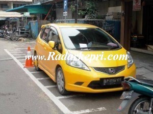 Honda Jazz yang digembok petugas Dishubkominfo karena parkir di lokasi untuk motor.