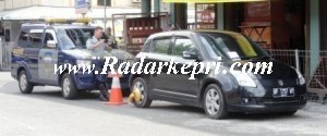 Petugas Dishubkominfo memotret mobil yang telah digembok di Jl Ketapang.=
