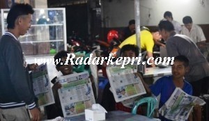 Tiga bocah penjual koran yang masih menjajakan korban meskipun telah malam.