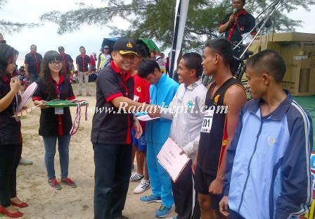Wakapolres Lingga, Kompol Darmeswara menyerahkan hadiah kepada pemenang maraton 10 K sampena HUT Bhayangkara ke 68.