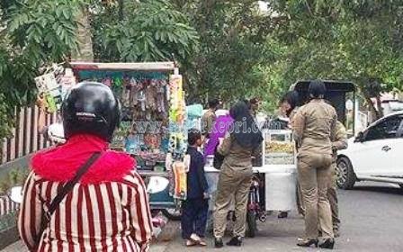 Petugas Satpol PP Pemko Tanjungpinang ketika mencatat dan menegur pedagang yang berjualan di depan SDN 02, Jl Engku Putri.